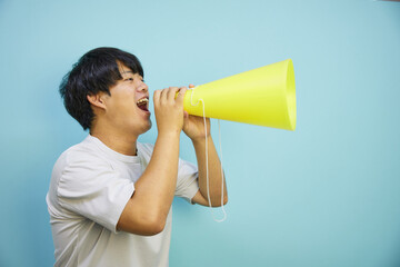 メガホンを持って叫ぶ白シャツの男性