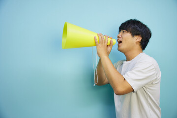 メガホンを持って叫ぶ白シャツの男性