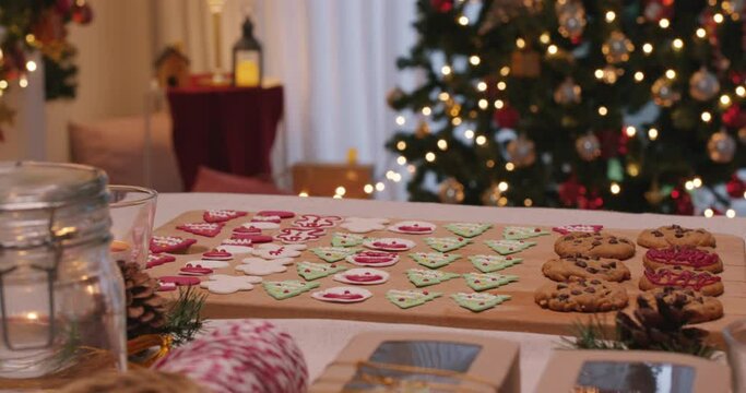 Merry Xmas eve moment with gingerman and santa claus colorful red green sugar icing snack on desk. Cute sweet food pastry dough for new year night party good warm time inside apartment house.