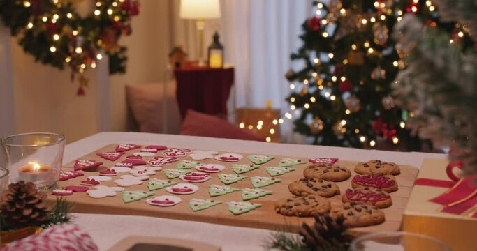 Merry Xmas eve moment with gingerman and santa claus colorful red green sugar icing snack on desk. Cute sweet food pastry dough for new year night party good warm time inside apartment house.