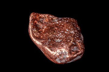 Macro mineral stone of a copper nugget on a microcline on a black background