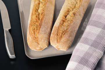 two mini baguettes on a black background - French cuisine