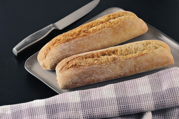 two mini baguettes on a black background - French cuisine