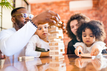 african american mixed race family at the table playing a board game with air conditioning