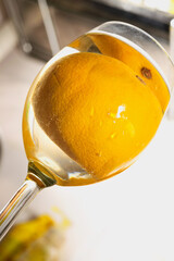 dynamic shooting angle from below on a glass with a whole orange in a drink in a glass. Refreshing lemonade concept.