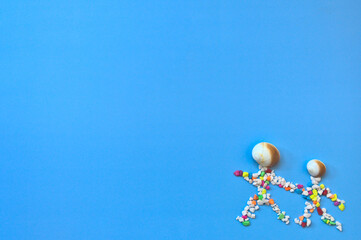 Conches and pebbles show an adult and a child holding hands, copy space