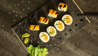 Salmon sushi and chopsticks on a black wooden board, Japanese cuisine, top view