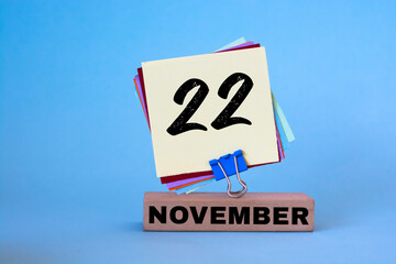 November 22nd. Day 22 of November month, calendar on workplace with blue background. Autumn time....