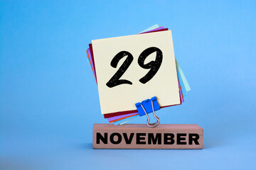 November 29th. Day 29 of November month, calendar on workplace with blue background. Autumn time. Empty space for text