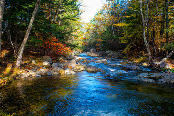 Rapids and swimming hole in fall foliage mountains 