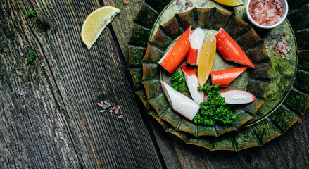 Delicious crab sticks on metal plate rustic wooden table. Long banner format. top view © Надія Коваль