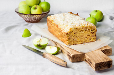 Apple and coconut loaf cake on wooden cutting board