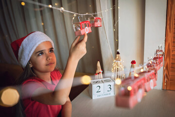 Happy kid opens crafted advent calendar on theme of skis and cable car. Ski resort funicular of...
