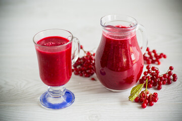 freshly squeezed thick natural juice with pulp from ripe red viburnum in a decanter