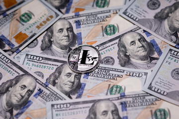 Silver Litecoins coin and US banknotes of one hundred dollars. Digital cryptocurrency close-up. Exchange, bussiness, commercial. Profit from mining crypt currencies