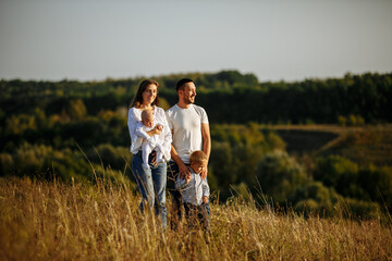 family in white t-shirts and blue jeans walking in nature