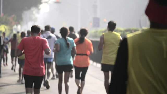 Slow motion back shot of tired Participant runners or joggers running in the last phase of city Marathon Mumbai, India