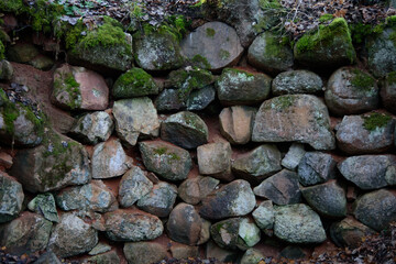 A beautiful stone wall in a nature park in the middle of the forest in autumn