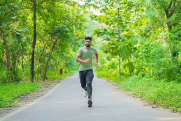 Young man running in the park at morning, also known as jogging or morning walk
