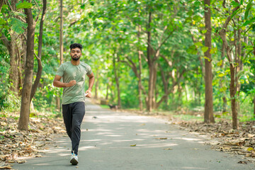 Young man running in the park at morning, also known as jogging or morning walk