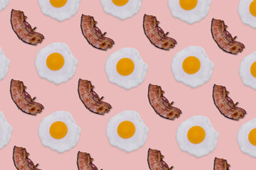 Pattern made with fried eggs and slices of crispy bacon on bright pink background.