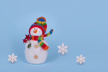 Cute Snowman with white flakes on blue background. Winter holiday concept.