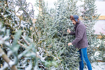italian man buying Christmas tree at X-mas new year in open air shop