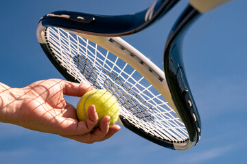 An athlete holds a tennis ball and racket before serving. Playing tennis outdoors.