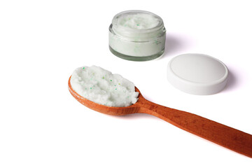 Body scrub with green crystals in wooden spoon. Homemade cosmetic for peeling and spa care. Isolated on white.