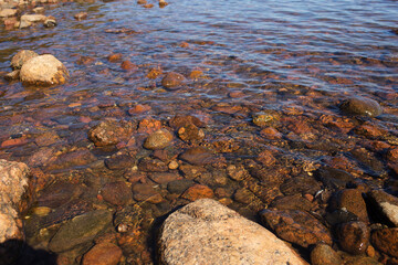 Sea waves lash the line of impact on the rock on the beach. Rocky plage, sea rocks close-up. Relaxing on the beach. Sea water