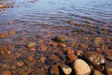 Sea waves lash the line of impact on the rock on the beach. Rocky plage, sea rocks close-up. Relaxing on the beach. Sea water