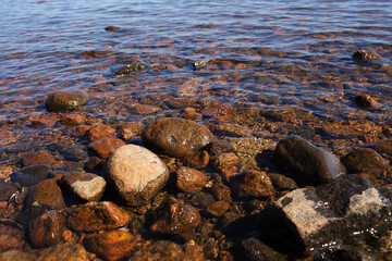 Sea waves lash the line of impact on the rock on the beach. Rocky plage, sea rocks close-up. Relaxing on the beach. Sea water