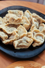 Homemade meat dumplings - russian pelmeni. Dumplings, filled with meat, ravioli. Dumplings with filling. Close-up.