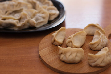 Homemade meat dumplings - russian pelmeni. Dumplings, filled with meat, ravioli. Dumplings with filling. Close-up.