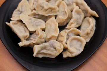 Homemade meat dumplings - russian pelmeni. Dumplings, filled with meat, ravioli. Dumplings with filling. Close-up.