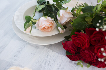 A bouquet of artificial red and white roses lies on a table in a white interior, a wedding bouquet for the bride. Decoration and interior design
