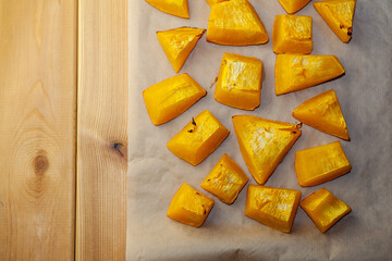 Pumpkin slices baked on a baking sheet in the oven. Homemade food, Vegan food, Healthy food, orange vegetables on a baking sheet and napkin, baked rustic vegetables, pop art, dessert during a diet