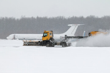 Airfield snow blower cleaning the runway at the airport in a severe blizzard