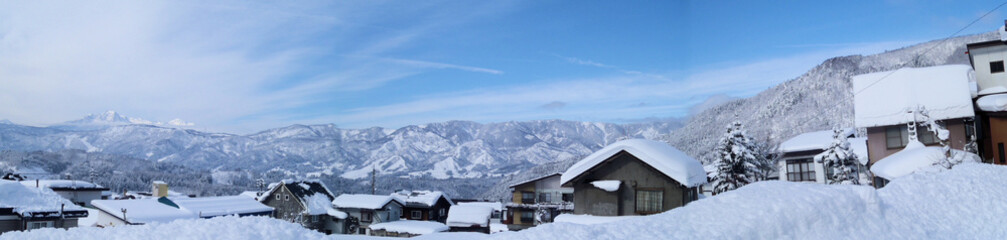 Fototapeta na wymiar 【長野】アルプス山脈をバックに雪化粧した家並み［パノラマ］