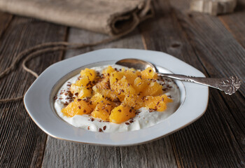 Skyr with oranges and linseeds on a plate for breakfast