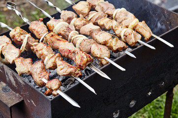 Marinated shashlik preparing on a barbecue grill over charcoal. Traditional Russian shashlik on a barbecue skewer