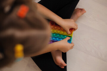Popit in the shape of a square as a fashionable silicone toy for fidgets. An exciting anti-stress toy in bright rainbow colors. Bubble alarm, pop it educational toys for kids.