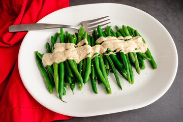 Green Beans with a Dijon-Tahini Sauce and Sesame Seeds: A platter of string beans topped with sauce...