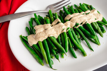 Green Beans with a Dijon-Tahini Sauce and Sesame Seeds: A platter of string beans topped with sauce and sesame seeds