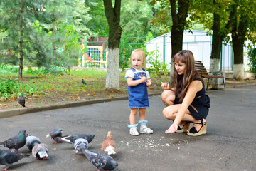 mother and daughter feed pigeons
