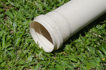 White water pipe on a green grass.