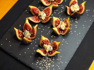 Cheese appetizer or wine snack set. Blue cheese, figs, honey,  on black stone concrete background