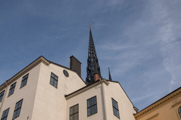 Fototapeta na wymiar Tower of the church Riddarholmskyrkan and old houses on the island Riddarholmen a part of the old town Gamla Stan in Stockholm