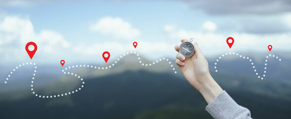Traveler hand holds a compass in the mountains during vacation. Horizontal banner with place for text © Shi 