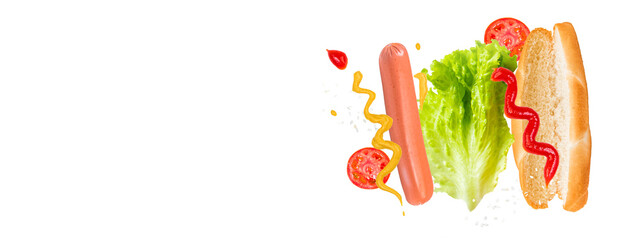 Flying ingredients for delicious hot dog on white background. Levitating sausage, tomatoes and lettuce.